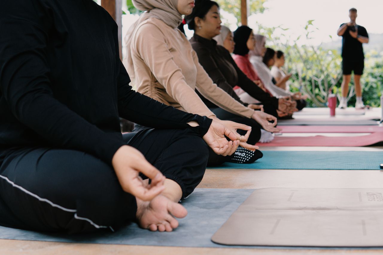 A diverse group practicing yoga outdoors in Jawa Barat, Indonesia. Relaxation and mindfulness in nature.
